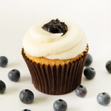 Fresh blueberry cake with cheesecake baked inside topped with cream cheese frosting and blueberry garnish