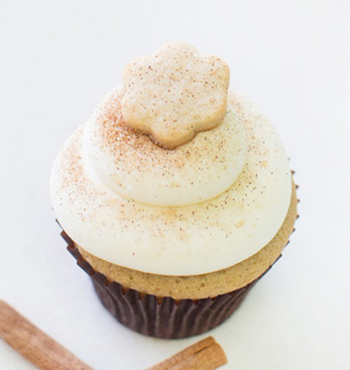 Cinnamon vanilla cake with buttercream icing sprinkled with cinnamon and sugar topped with a mini Snickerdoodle cookie